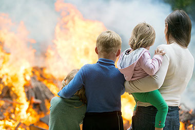 Image of mother and children in front of a house fire.