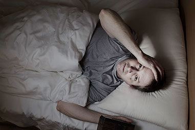 Image of male in bed awake.