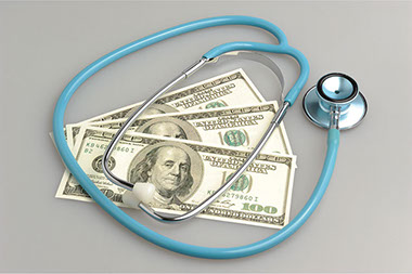 Image of money and a stethoscope.