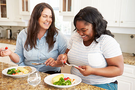 Image of two friends eating healthy.