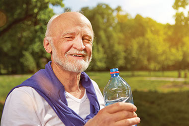 Elderly man drinking water.
