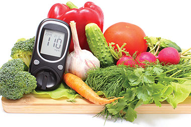 Image of home testing glucose machine surrounded by vegetables.