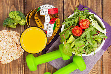 Healthy salad, fitness weights, and tape measure.