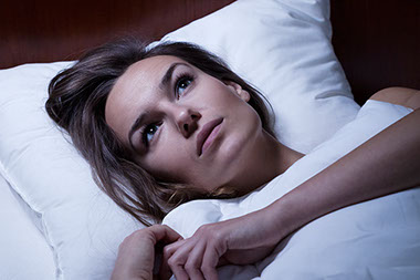 Image of women awake in bed.