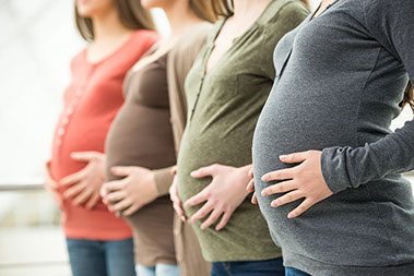 Close up image of 4 pregnant bellies.