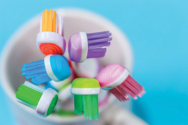 Dangers of tooth brushing. Image of tooth brushes in a cup.