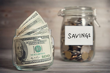 How to set up an emergency fund. Image of money in savings jar.
