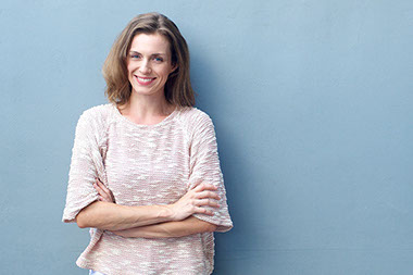 Adult woman smiling with arms crossed.