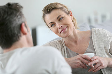 Mature couple talking together on sofa.