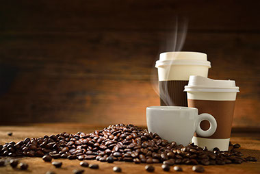 A jolt of java. Image of 3 coffee cups around coffee beans.