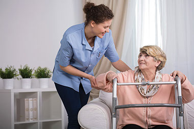 Image of older women recieving help to sit.