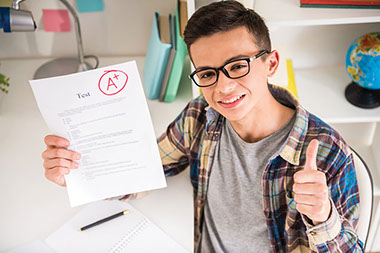 Tips to help kids succeed. Image of kid holding an 'A' graded paper with thumbs up.