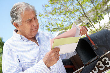Image of man getting mail from mailbox.