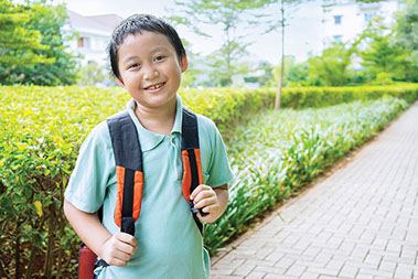 Smiling boy wearing a backpack.