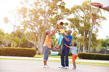 Summer with less screens. Image of grandparents playing basketball with grandkids.