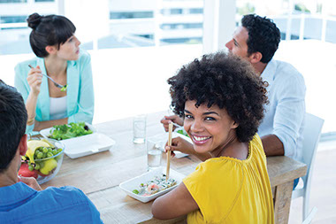 Why you shouldn't eat at your desk. Image of co-workers wating lunch together.