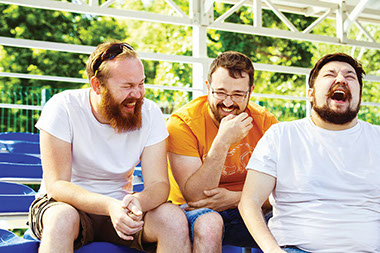 Image of 3 male friends laughing with each other.
