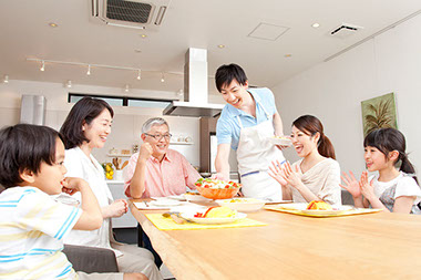 Three generation family eating dinner at home.