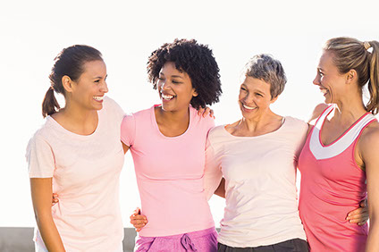 Image of 4 women with arms around each other smiling and laughing.