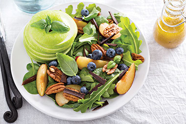 Colorful salad with green apples, blue berrties, and walnuts.