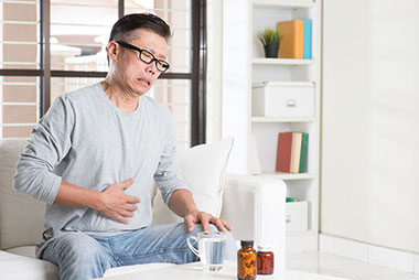Image of man holding his stomach in pain.