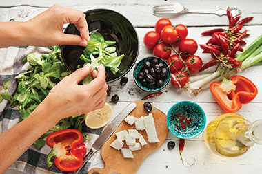 Hand over table with bowls of different, healthy ingredients.