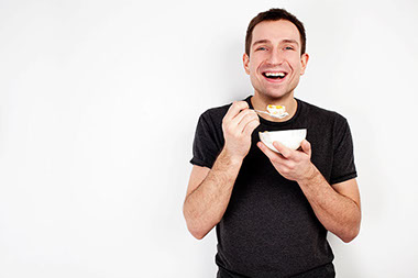Young smiling man eating on diet.