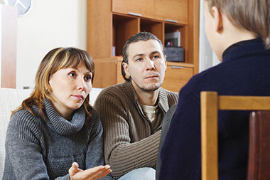 Talk to your child about abuse. Image of parents talking to their child.