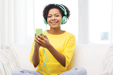 Image of young women smiling while listening to music from her smart phone.