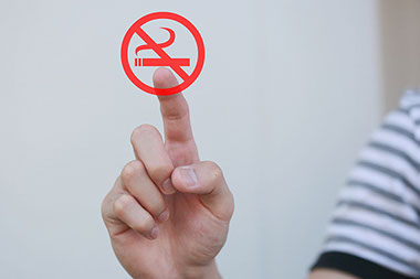 Man's hand touching an abstract no smoking.
