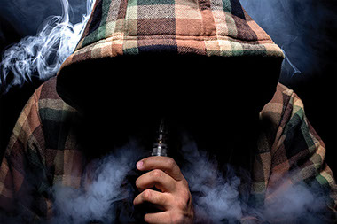 Man with hoodie vaping.