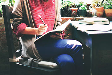 Person writing in a notebook.