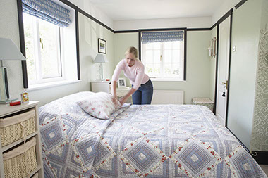 Don't let the bed bugs bite. Image of women making bed.