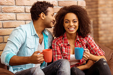 Image of happy couple talking while drinking coffee.
