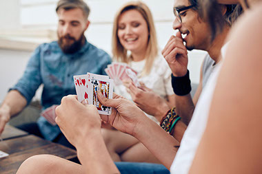Image of friends playing cards.
