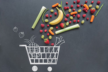 Chalk drawing of shopping cart with fresh fruit above.