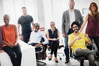 A diverse group of co-workers sitting around at the office.