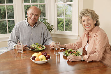 Image of mature couple eating at home.