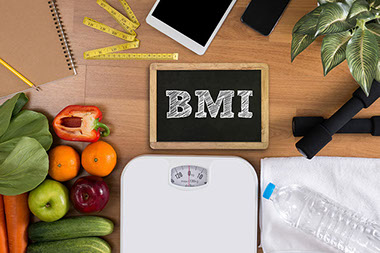 Dumbbells, scale, towel, fruit, BMI body mass index formula rate formula in a board. Dumbbells, scale, towel, fruit, BMI body mass index formula rate formula in a board.