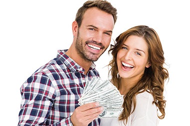 Young couple smiling and holding money.