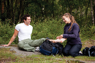 Women helping wrap man's foot and ankle with sprain wrap.