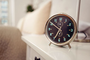 Clock sitting on night stand.