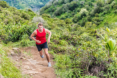Man running along hiking trail.