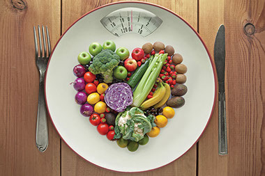 Image of scale shaped as a plate with fruits shaped as a heart.