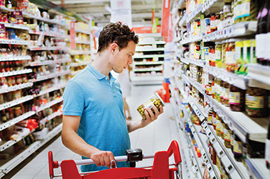 Man reading food label in the grocery store. Man reading food label in the grocery store.
