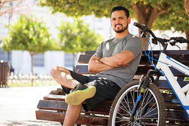Man sitting on bench beside his bike.