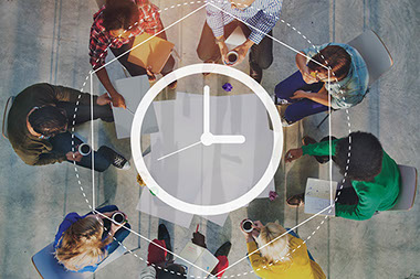 Image of clock super imposed on an image of employees sitting in a circle.