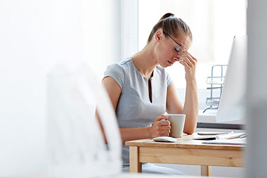Overwhelmed at work? How to handle it. Image of stressed women at work.