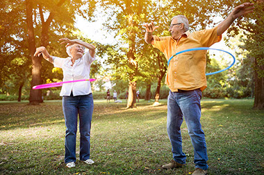 Older couple hula hooping.