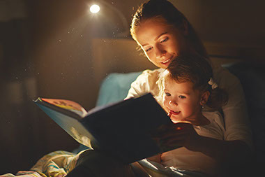 Image of mom reading to child before bedtime.